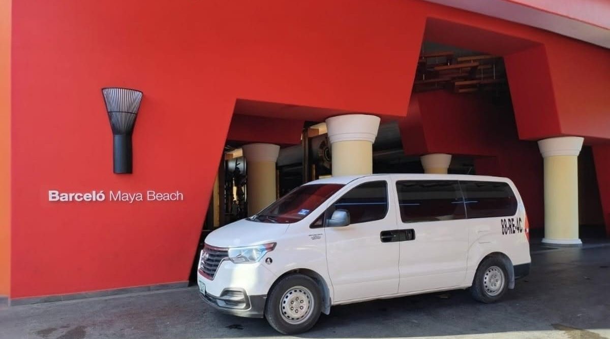 Van Hyundai H1 blanca de Comfort & Safety Transport en la entrada de un hotel de la Riviera Maya